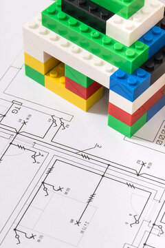 Small house made of toy blocks and electrical diagrams of house. Building home
