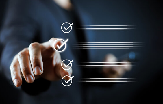 Businessman hand touching virtual screen to select checklist, task completion, and quality assurance. Concept of digital workflow management, project success, and corporate business efficiency.