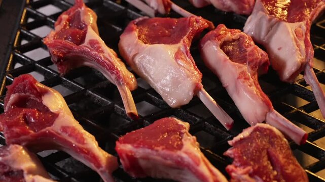 Fresh Lamb Steak is being grilled in Restaurant by professional Cook. Chef is Cooking Juicy Roasted Lamb Meat.