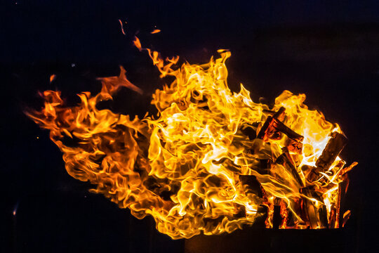 Close-Up Of Intense Wood Fire Flames And Burning Logs In Hot Orange Bonfire