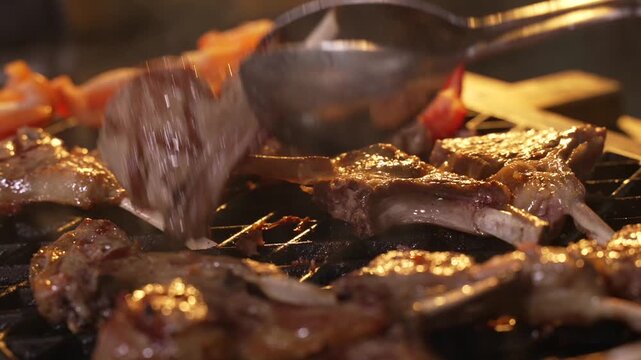 Fresh Lamb Steak is being grilled in Restaurant by professional Cook. Chef is Cooking Juicy Roasted Lamb Meat.
