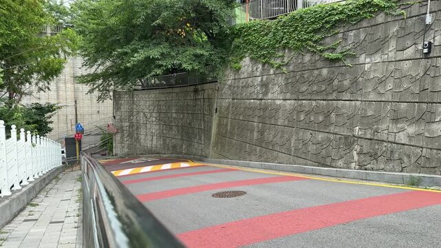 Steep Residential Road with Crosswalk, Speed Hump and Stone Wall