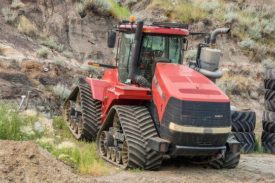 DRUMHELLER, ALBERTA, CANADA - 25 JULY, 2026. Case IH Steiger 500 Quadtrac heavy track tractor parked by a soil slope at an Rocky Mountain Equipment.
