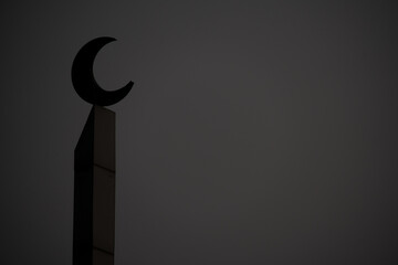 Silhouette of mosque minaret crescent moon symbol against dark moody overcast sky background © EkoPriyatno
