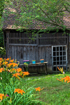 Traditional Romanian House with Thatched Roof and Wooden Fence