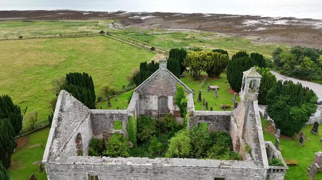  drone video of Kiltearn Old Parish Church ruins, historic burial ground, and Cromarty Firth coastline, Evanton, Scottish Highlands, Scotland, UK