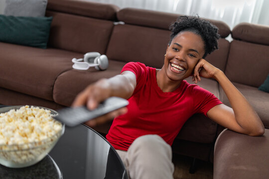 Enjoying a movie night at home with popcorn and a remote control in relaxed setting