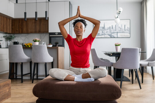 Woman practicing yoga at home in a modern living space during the day