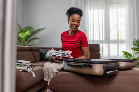 Packing clothes for a trip in a living room during daytime
