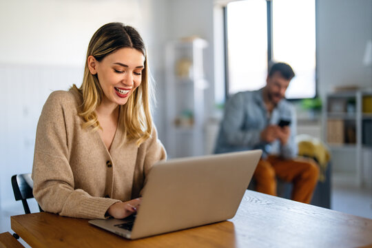 Woman working on laptop online, checking emails and planning on the internet at home office