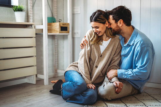 Happy couple smiling and enjoying a loving relationship at home, expressing joy and shared happiness