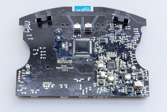 Intricate black PCB showing chips, capacitors, and electronic components