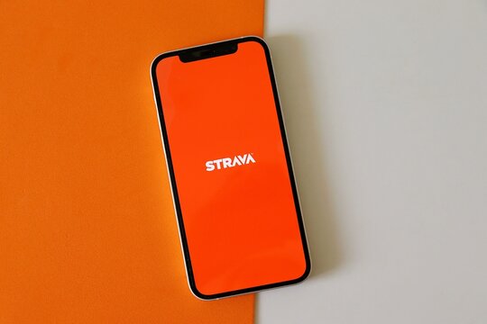 Salvador, Brazil - August 16, 2026: Strava app on smartphone screen o orange background. Fitness concept.