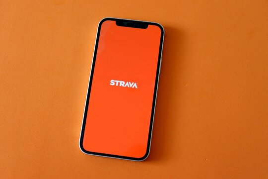 Salvador, Brazil - August 16, 2026: Strava app on smartphone screen o orange background. Fitness concept.