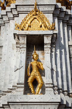 Scene featuring gold guard on tower, in buddhist temple Wat Phi, Bangkok, Thailand
