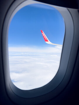 View from a passenger window aboard a VietJet Air aircraft during flight above the clouds, with the airline's branded winglet visible.