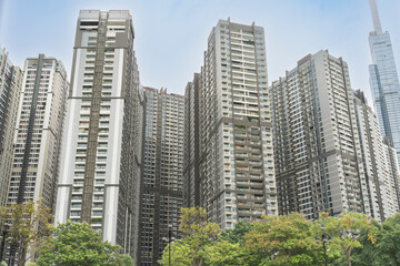 Fototapeta premium Modern high-rise residential apartment towers towering over green trees, with Landmark 81 visible in the background in Ho Chi Minh City, Vietnam.