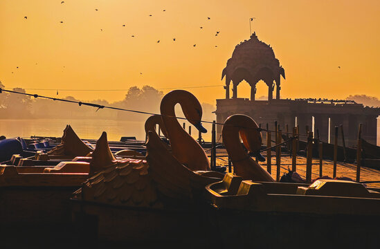 Swan Pedal Boats and Stone Chhatri Silhouette at Sunrise on Gadisar Lake in Jaisalmer Rajasthan India