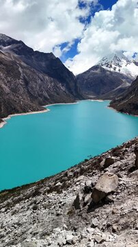 Vertical aerial view of the turquoise waters of Laguna Par&oacute;n, with snow-capped peaks of the Cordillera Blanca in Huaraz, Peru. Hikers enjoying a breathtaking view after trek. 