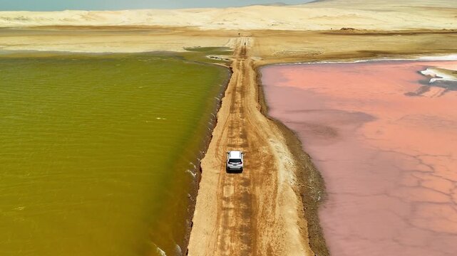 Aerial drone view of a car at Las Salinas de Otuma. The lake is located in the Paracas National Reserve, Ica, Peru. Road trip.	
