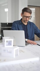 Fototapeta premium Architect man designing new building structure, carefully developing a modern architectural model in office, focusing on creating innovative housing plans and contemporary development concepts