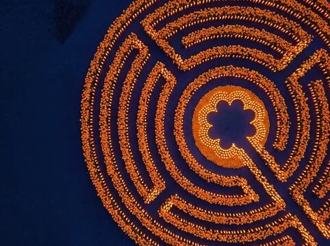 Aerial view of circular candle maze with marigold flower center for festival background and ceremonial banner design