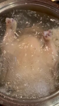 The chicken is cooking in boiling water 
