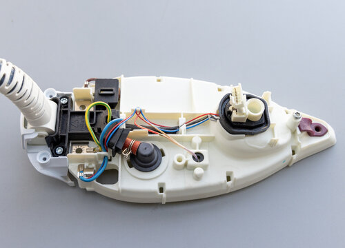 Detailed View of Deconstructed Electric Steam Iron Internal Wiring and Parts