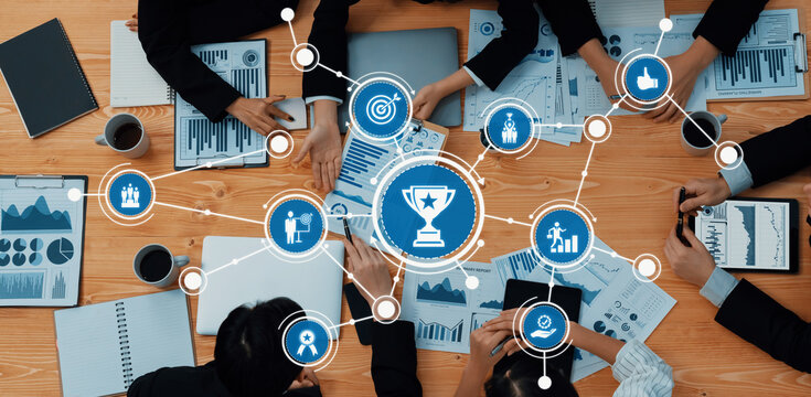 Aerial view of a collaborative business meeting with professionals analyzing charts and reports, focused on strategic planning, goal setting, and achieving success together. Amity