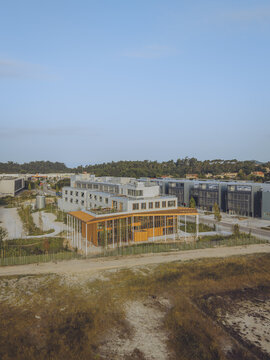 Pontevedra, Spain - 08 August 2026: Aerial view of the BorgWarner eSTC building, a modern facility with wooden facade elements and a green roof, set in an industrial park under a clear sky.