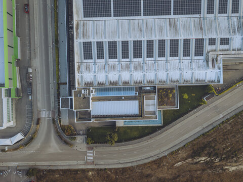 Pontevedra, Spain - 08 August 2026: Aerial view of Delta Vigo Aeroestructuras industrial facility with solar panels on the roof, adjacent roads, and surrounding green spaces.