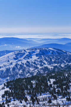 Aerial view of mountain ridges in soft fog and sky. Beautiful white blue peaks Altay mountains fades in distance. Minimal Nature abstract photo, natural winter picturesque scene, panoramic skyline.