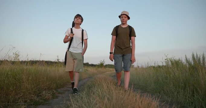 Two friends boys hike walking on nature. Teenagers spending time together. 4K 10-bit