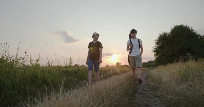 Two friends boys hike walking on nature. Teenagers spending time together. 4K 10-bit