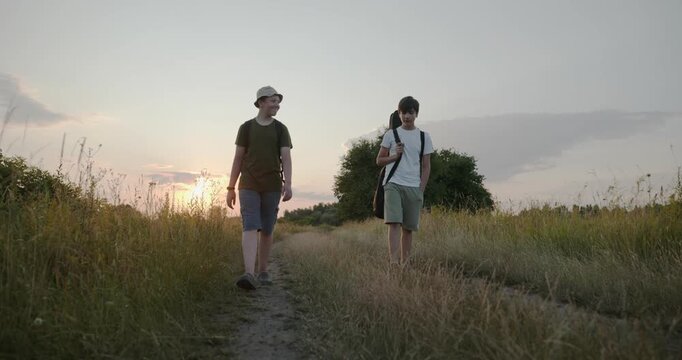 Two friends boys hike walking on nature. Teenagers spending time together. 4K 10-bit