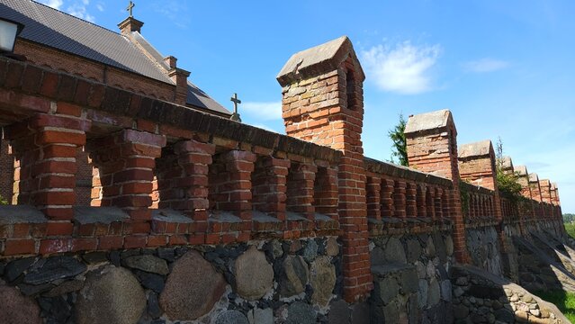 Old brick wall with arches and a background of blue sky  