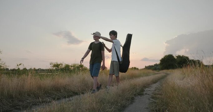 Two friends boys hike walking on nature. Teenagers spending time together. 4K 10-bit