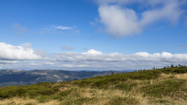 Mountain landscape with dry meadow under clear blue sky