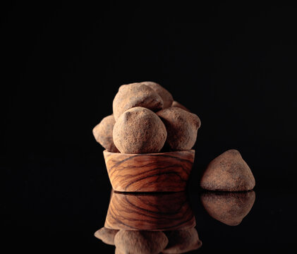 Chocolate truffles in small wooden dish.