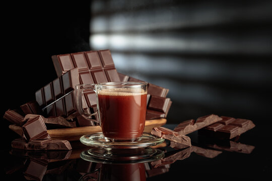Mug of hot chocolate against broken bitter chocolate bars.
