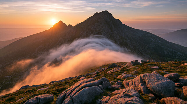 Golden sunrise illuminates mountain peaks as low clouds roll over rocky ridges. Ideal for nature travel and wilderness adventure campaigns.