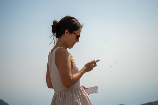 Female Traveler Using Smartphone and Paper Map Outdoors, Mobile Navigation and Trip Planning Concept During Summer Vacation
