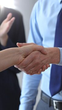 Business people shaking hands, concluding a deal, and celebrating success with an agreement and partnership in a corporate office environment
