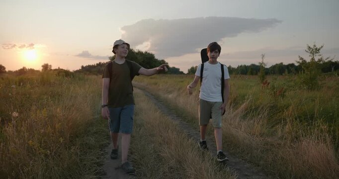 Two friends boys hike walking on nature. Teenagers spending time together. 4K 10-bit