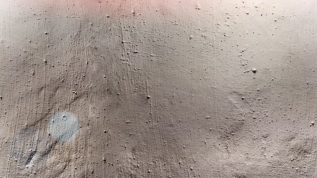 Seamless 4K looping vertical movement across a beige plaster wall with soft weathered texture and subtle imperfections. Perfect for neutral backgrounds and architectural visuals.