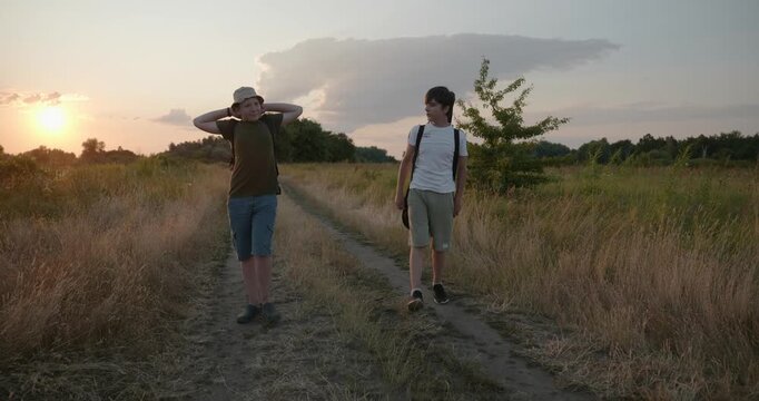 Two friends boys hike walking on nature. Teenagers spending time together. 4K 10-bit