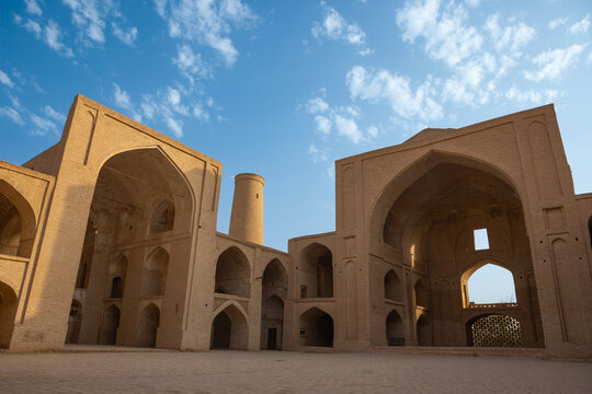 Ardestan Grand Mosque, a historic four-iwan mosque in Ardestan, Isfahan Province, Iran. The photograph shows the central courtyard surrounded by monumental brick iwans and vaulted spaces.