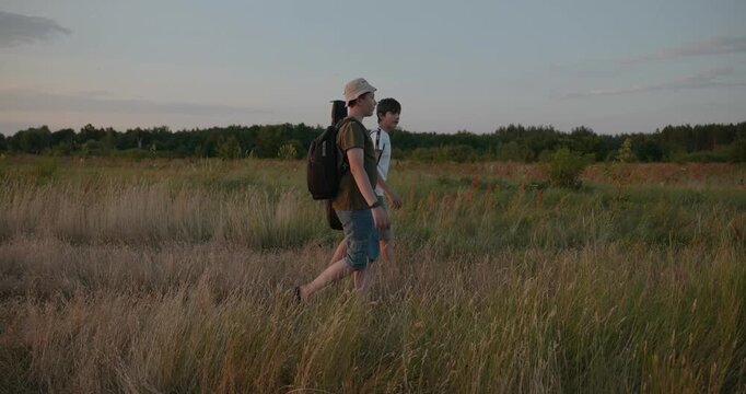 Two friends boys hike walking on nature. Teenagers spending time together. 4K 10-bit