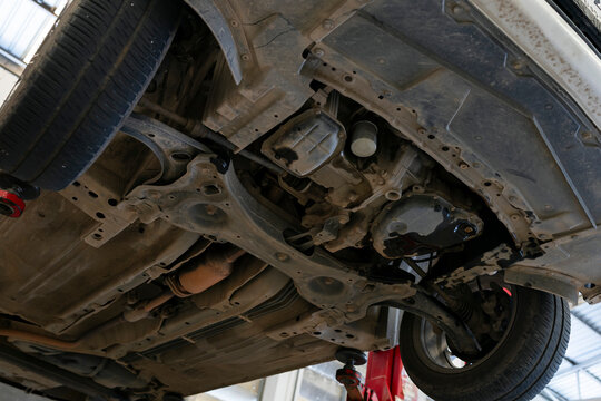 Underside of car on lift in auto repair workshop