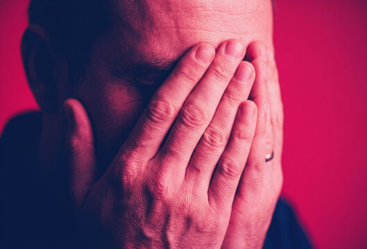 Man covering his face with hands in distress